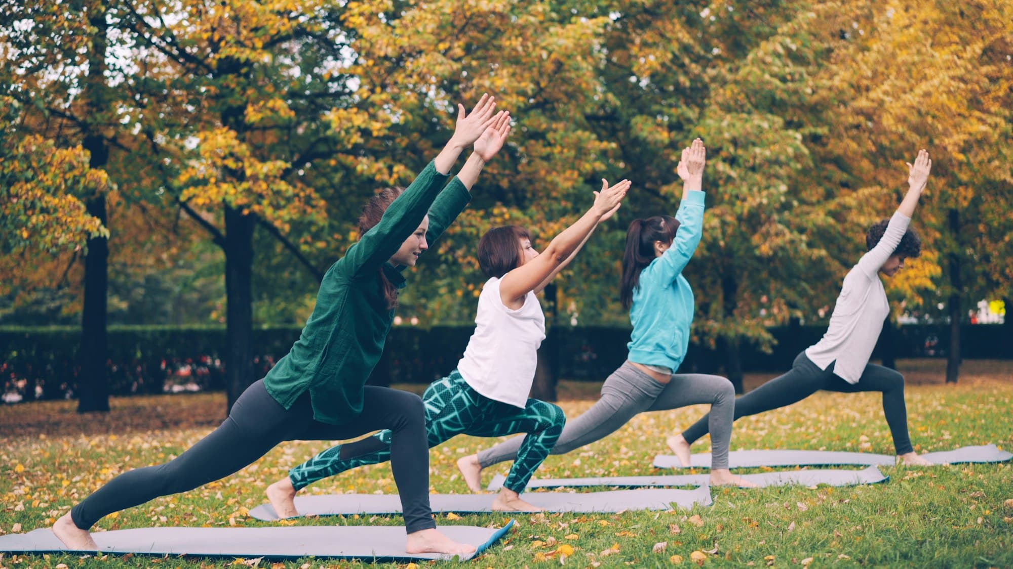 Grupo praticando yoga em um parque, em aula leve ao ar livre